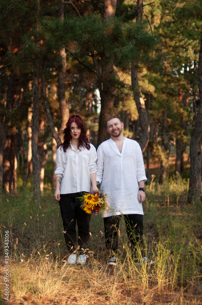 Obraz premium Happy couple standing in a forest on a sunset