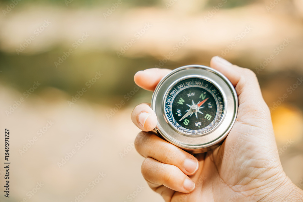 Fototapeta premium Traveler holds a compass in a park finding her way amidst confusion. The compass in her hand symbolizes guidance exploration and the journey to conquer defeat.