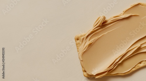 Close-up of a piece of bread with a generous amount of peanut butter spread on top. the peanut butter is a light beige color and has a smooth texture.