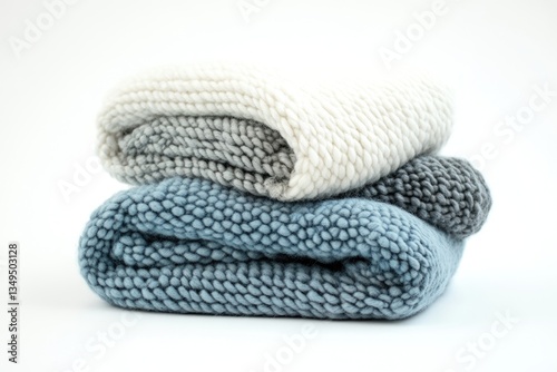 Stack of three chunky knit blankets in varying shades of blue and white, soft and cozy.
