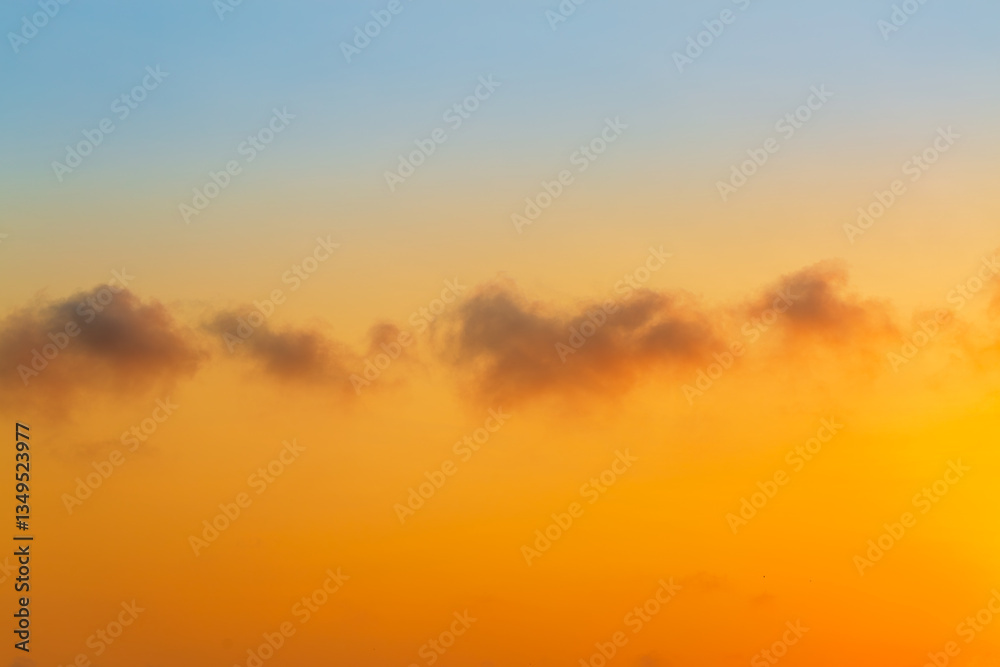 Fototapeta premium Clouds and orange sky,Beautiful Vivid sky painted by the sun leaving bright golden shades,Yellow sunlight in Golden hour or morning sunrise, Horizon sky nature background