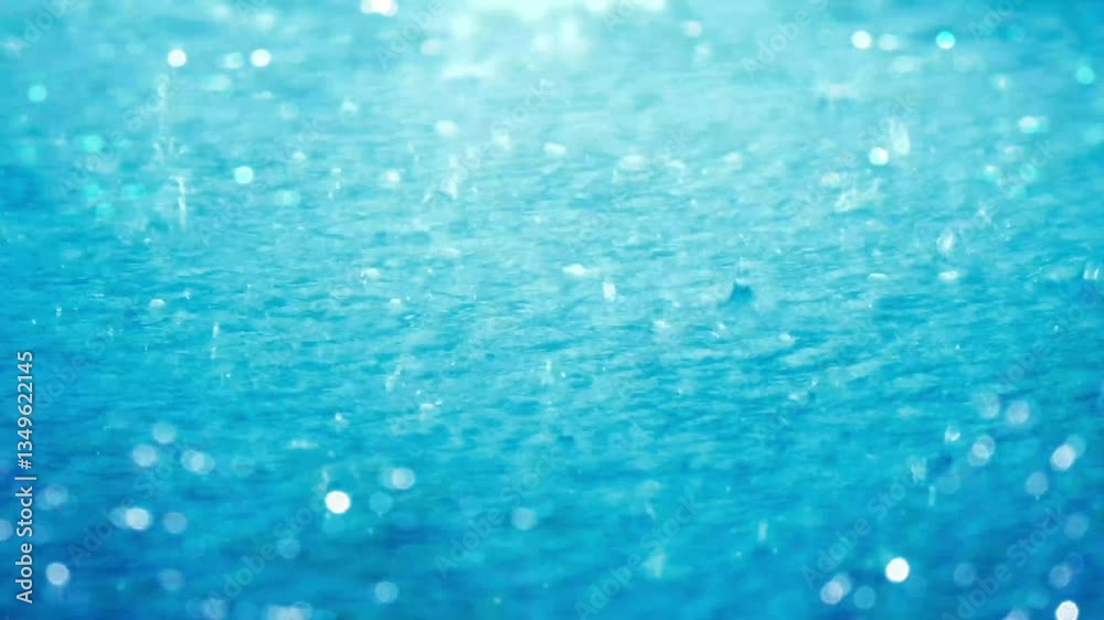 closeup of splashing raindrops in blue water surface of a puddle with defocused glittering lights, sunny nature scene background on a summer day with copy space closeup of splashing raindrops in blue water surface of a puddle with defocused glittering lights, sunny nature scene background on a summer day with copy space
