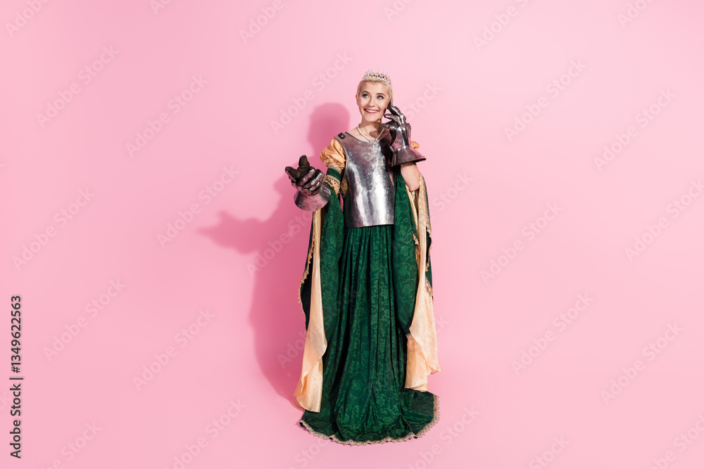 Fototapeta premium Elegant woman in medieval royal attire on a pink backdrop