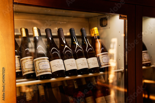 Milan, Italy - October 3, 2024: Bottles with collection wines stand on shelves in a wine refrigerator