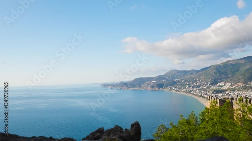 Majestic zooming in shot of Cleopatra Beach from Alanya Castle – Historic Stone Tower Framing Turquoise Mediterranean Coastline (4K Still Shot)