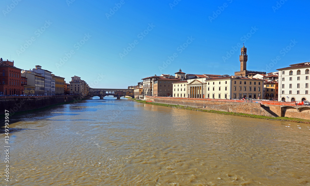 Obraz premium large ARNO river in Florence in central italy with the Ponte Vecchio and the tower of the Palazzo della Signoria in the background