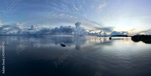 Quadro su tela An exquisite sunrise illuminates the calm seas surrounding the Togian Island of Central Sulawesi, Indonesia