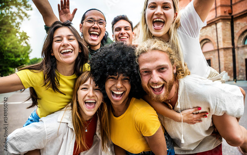 Multicultural group of young people smiling at camera outdoors - Happy friends having fun on city street - Youth community with diverse guys and girls hugging together