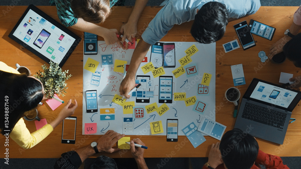 Fototapeta premium Top view of developer team sharing idea of Ux Ui design by using mind map. Top down view of group of business people working together to brainstorm or plan mobile phone interface app. Convocation.