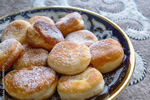 Homemade golden fried dough pastries with powdered sugar photo