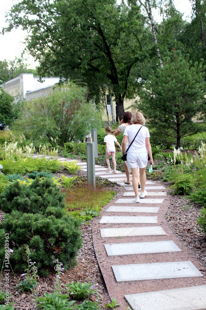 Fototapeta premium People are walking along a beautiful path in the park.