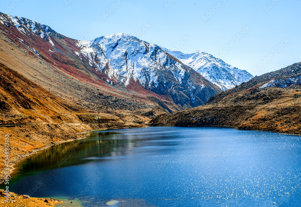 Fototapeta premium SNOWY MOUNTAIN PEAK WITH BEAUTIFUL LAKE