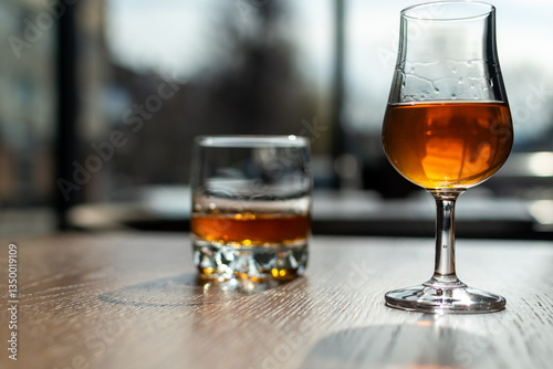 Glass of spirit drink close-up on the restaurant table on blurred background of street