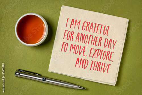 I am grateful for another day to move, explore and thrive - morning positive affirmation on a napkin with tea