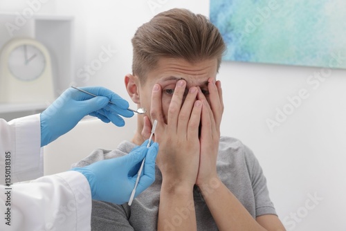 Фотография Scared man covering face and dentist with tools in clinic