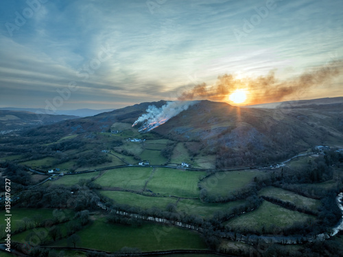 Canvastavla A grass fire at sunset on a hillside in the Brecon Beacons in South Wales GB