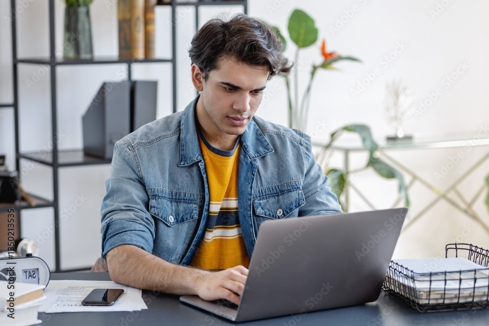 Concentrated young man freelancer working on laptop
