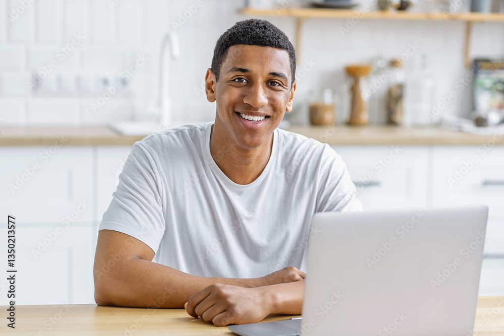 Male student studying or working on laptop remotely at home