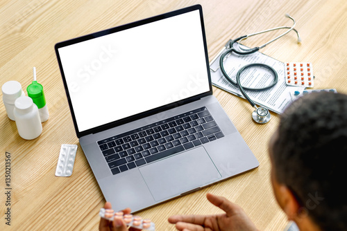 Doctor consulting online with laptop and medicine