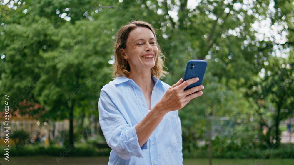 Woman enjoy video phone conversation walking urban park closeup. Lady greeting Woman enjoy video phone conversation walking urban park closeup. Lady greeting