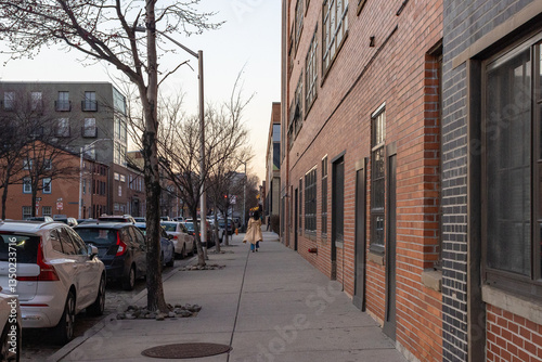 Woman with Dark Hair and Light Beige Trench Coat Walking Down City Sidewalk 