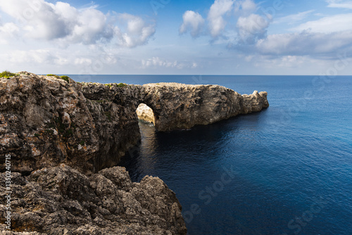 Pont d'en Gil in Ciutadella, Menorca, bridge from the rock in the sea, arch in the cape, lonely person on the end of the rock