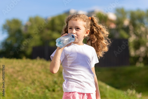 little girl drinking water from bottle in heat. kid suffering from thirst. prevention of dehydration on sunny day. thirsty child drink liquid for hydration, wellness, health