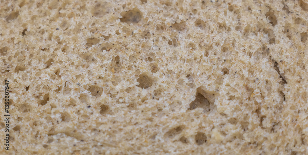 Close-up of the texture and pattern on a slice of freshly baked whole wheat sourdough bread. A macro photography shot focusing on the detailed textures of the bread's surface Close-up of the texture and pattern on a slice of freshly baked whole wheat sourdough bread. A macro photography shot focusing on the detailed textures of the bread's surface