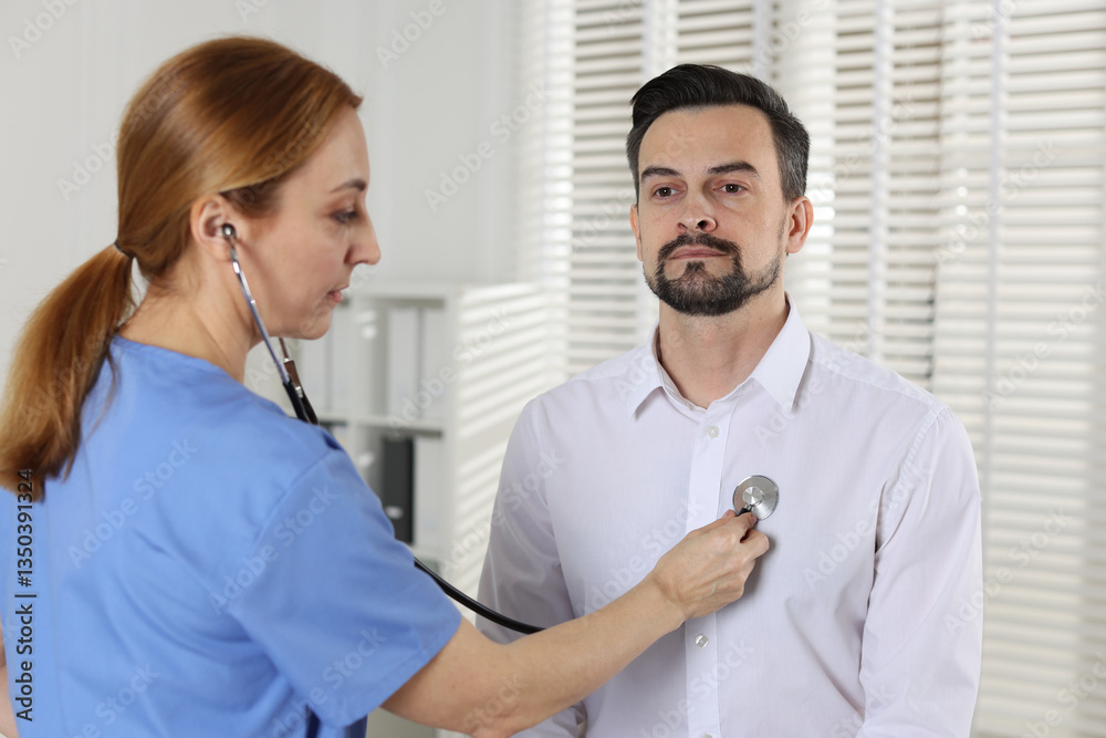 Φωτογραφία Cardiologist with stethoscope listening patient's heartbeat in hospital