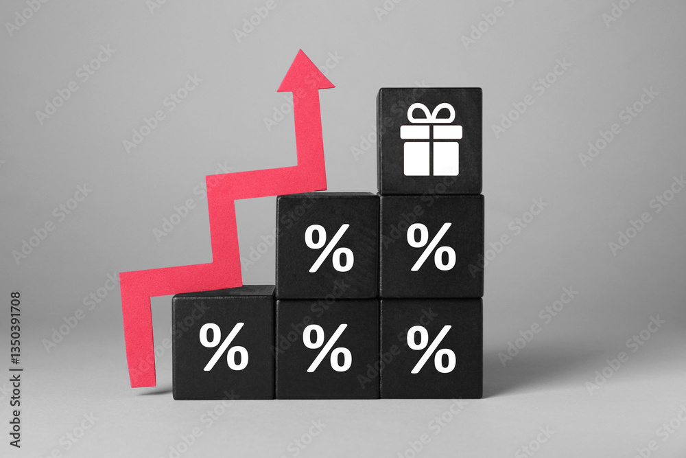 Cube with gift box image on top of stacked ones with percent signs and red wooden arrow against grey background Cube with gift box image on top of stacked ones with percent signs and red wooden arrow against grey background