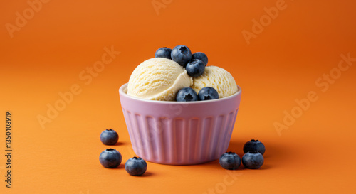 Vanilla Ice Cream Scoops topped with Fresh Blueberries on Orange Background. Frozen Summer Treat. Organic. Homemade