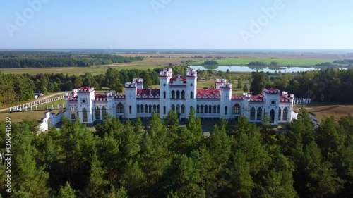 The Puslovsky Palace in Belarus. The Kossovsky Autumn Castle. An old historical castle in the style of English Gothic Revival in Kosovki in sunny autumn weather.Top view.Drone.4K photo