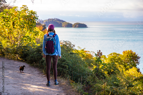 backpacker girl enjoys the coast of Abel Tasman National Park, New Zealand South Island