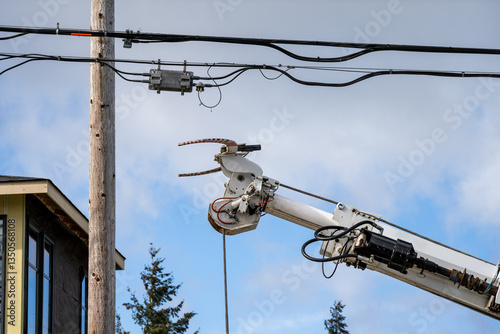 Utility digger derrick truck with pole setting equipment, ready to remove temporary wood powerline pole, infrastructure upgrade supporting new housing development

