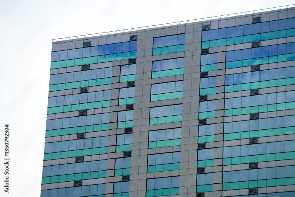 Fototapeta premium Modern Glass Building with Reflective Windows and Geometric Design