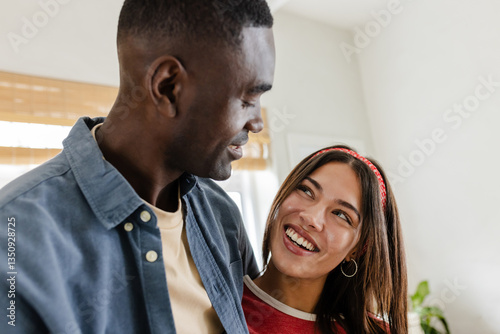 Wallpaper Mural Smiling Diverse couple enjoying quality time together at home, sharing joyful moment Torontodigital.ca