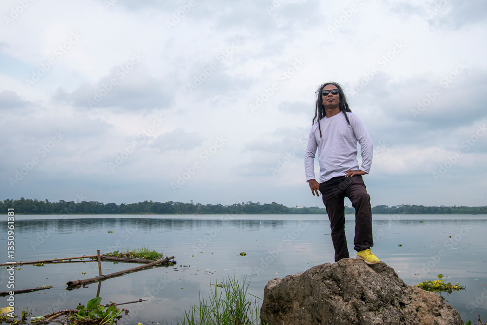People enjoy the beauty of Lake Karangkates, Indonesia. Model is posing while being photographed People enjoy the beauty of Lake Karangkates, Indonesia. Model is posing while being photographed