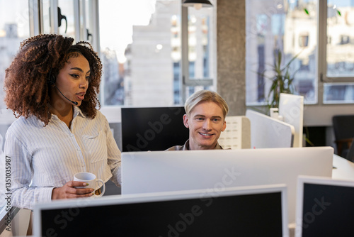 Tableau sur toile Customer service representative assisting colleague with computer issue in moder