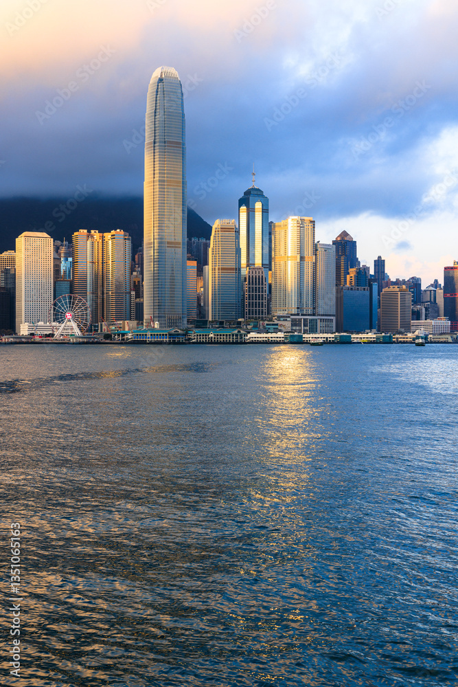 Fototapeta premium The view from Victoria Harbour and the skyline of skyscrapers on Hong Kong Island, at sunrise in Hong Kong of China