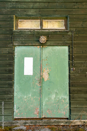 Old shabby door of a wooden building with a retro lamp.