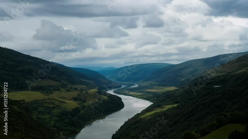 Wallpaper Mural A winding river flowing through lush green mountains under a cloudy sky. 4k Video footage. Torontodigital.ca