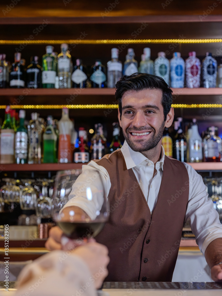 Bartender giving glass of wine to woman customer at bar counter .