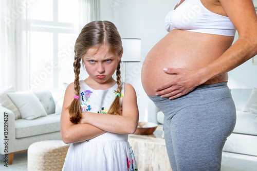 Obraz na płótnie A angry girl stands next to her pregnant mother being not happy about her future sibling to be born w salonie