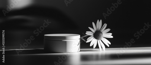 Obraz na płótnie A simple still life featuring a flower next to a jar of cream w salonie