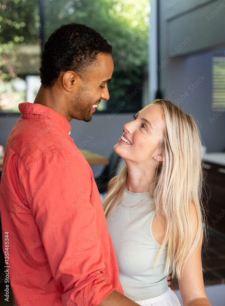 Diverse couple embracing at home, smiling and enjoying each other's company Diverse couple embracing at home, smiling and enjoying each other's company