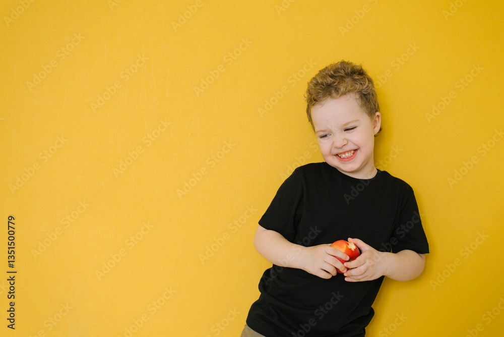 Boy Holding A Red Apple By Yellow Wall
