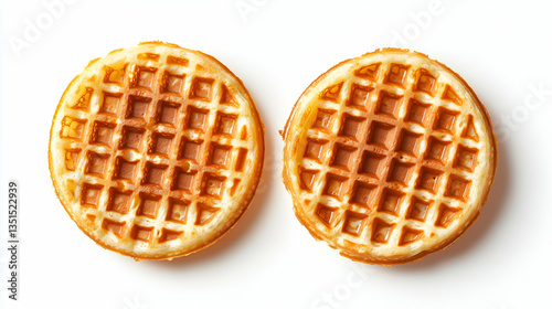 Two golden round waffles with crispy grid texture. Breakfast food with even browning placed on white background.