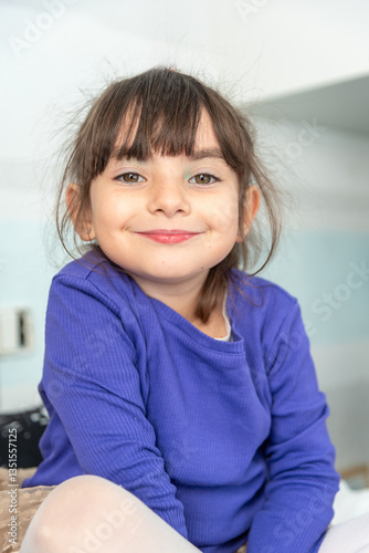 Portrait of smiling young girl with makeup posing indoors