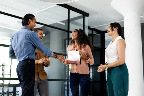 Diverse business team celebrating colleague receiving award in modern office