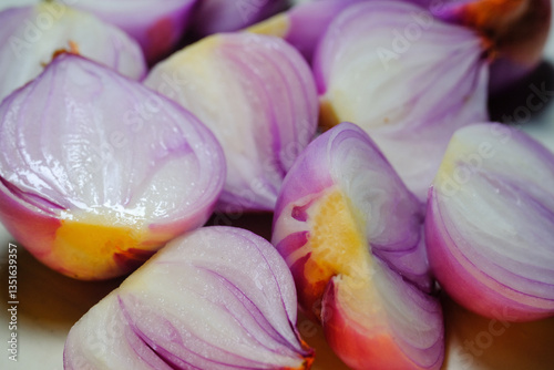 A bunch of peeled shallots. Shallots and shallot skins photographed in studio with white backgrounds. Spices and raw materials. Kitchen ingredients. Layered bulbs. Purple shallots. Macrophotography